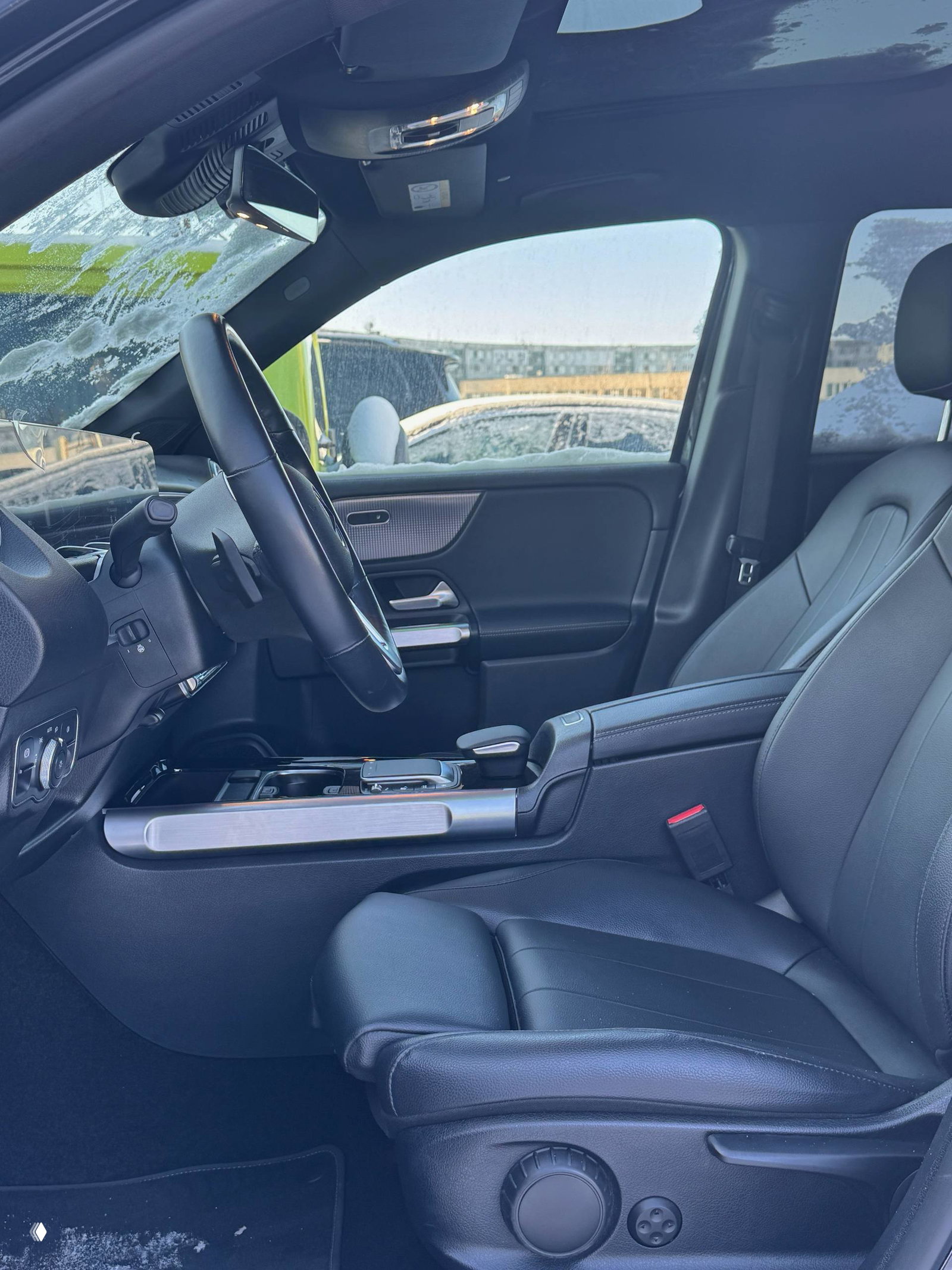 Переднее сиденье и центральный тоннель Mercedes GLB с кожаной отделкой и видимой панорамной крышей — интерьер и посадочная позиция водителя.