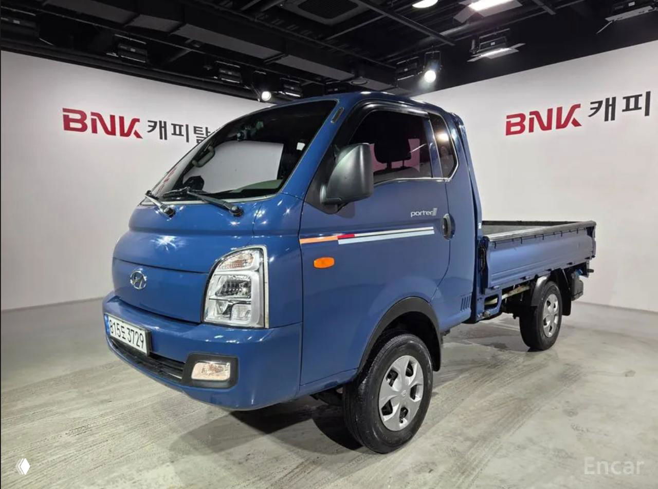 Синий Hyundai Porter, общий вид сбоку и спереди на площадке, подборка фотографий кузова и колёс для оценки внешнего состояния.