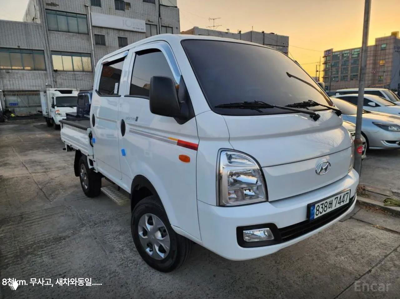 Двойная кабина Hyundai Porter с бортом и регистрационным номером, внешний снимок на стоянке — демонстрация кабины на 5 человек и общего вида.