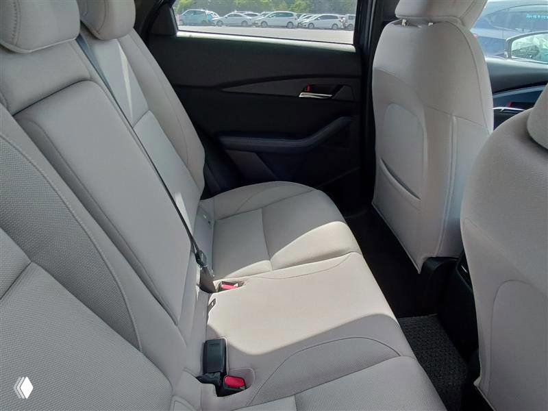 Салон Mazda CX-30 2023 — задние сиденья автомобиля, светлая обивка, видно чистое состояние и ремни безопасности на местах.