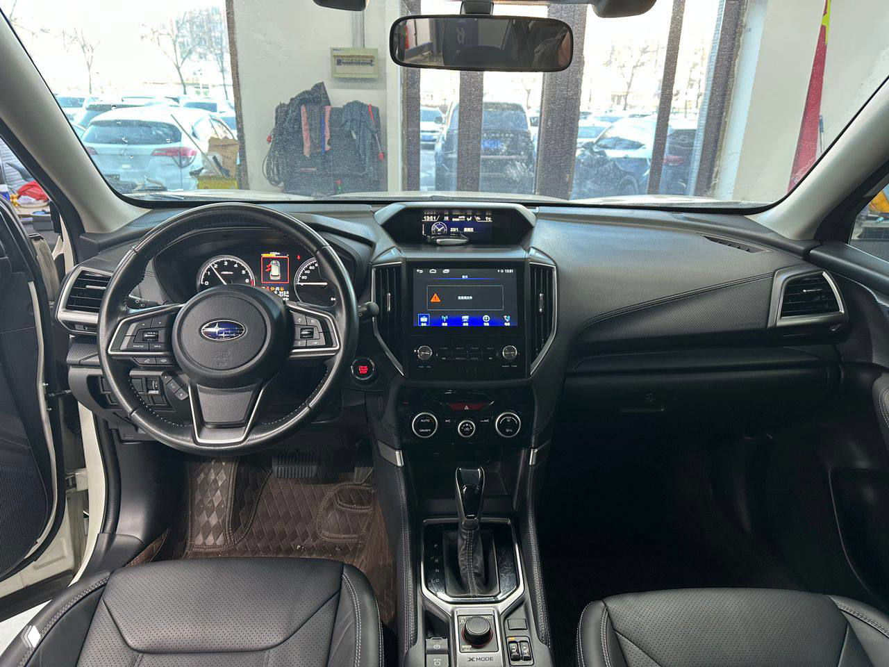 Интерьер Subaru Forester: общая панорама передней части салона, мультимедиа, центральная консоль и рулевое колесо, состояние салона видно на фото.