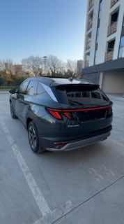 Вид сзади Hyundai Tucson 2025 на стоянке: задние фонари, спойлер и нижняя часть бампера, автомобиль в городском дворе.