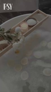 Ванна с пеной, свечи и цветы на деревянной подставке — мягкая атмосферная сцена, символ успокоения и минутки заботы