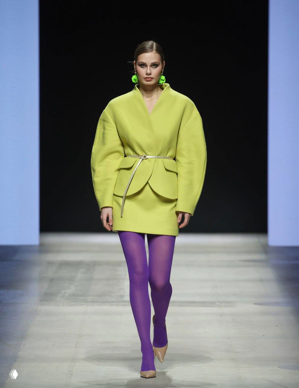 Модель в лимонном жакете и ярких сиреневых колготках на подиуме Koss — пример контрастного цветового сочетания из новой коллекции бренда.