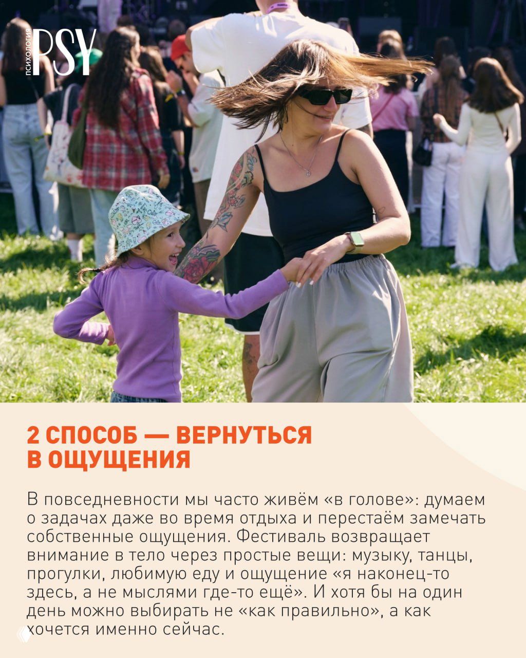 Мама с татуировкой танцует с ребёнком на фестивале на зелёной поляне; на заднем плане видна толпа и сцена, атмосфера живого отдыха.