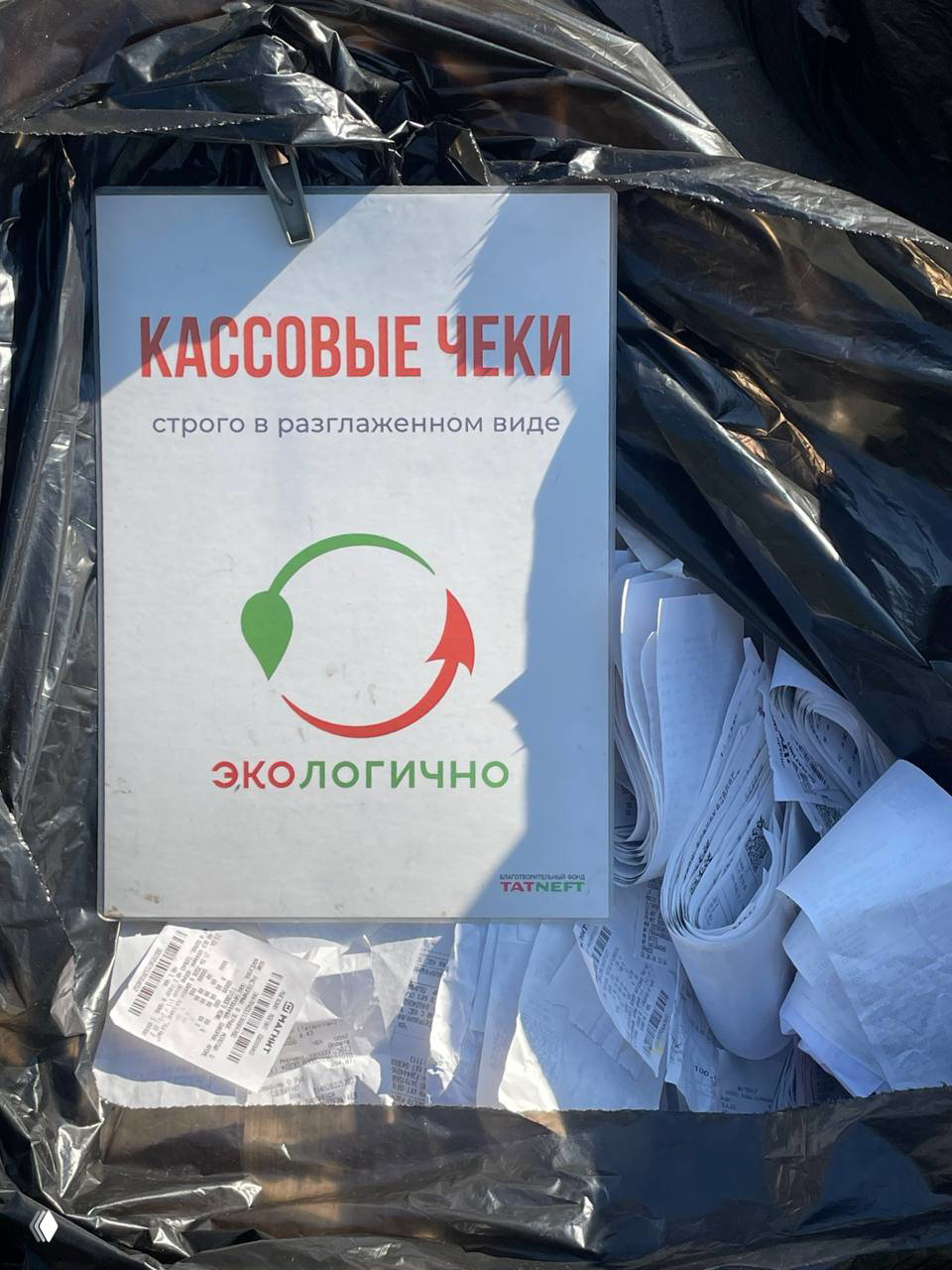 Рука в перчатке демонстрирует пластиковые крышки в руках над контейнером для крышек — пример собираемой фракции для переработки.