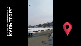 Видео-кадр: дорога и стоянка у торгового комплекса зимой, видны фонарь, припаркованные машины и ориентир к КультТоргу.