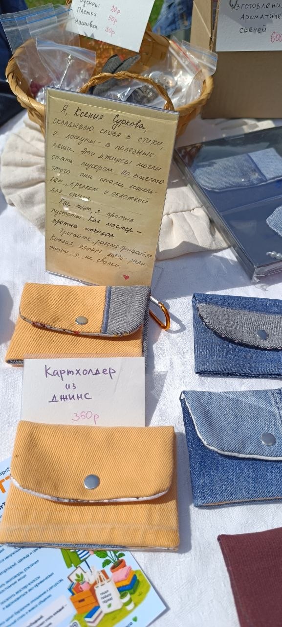 Прилавок с небольшими картхолдерами и текстильными кошельками из джинса и ткани; ценник 350₽ на одном изделии — рукодельные товары на фестивале.