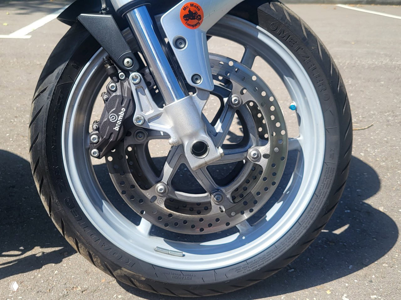 Крупный план переднего колеса и тормозной системы Ducati Multistrada 1000DS с суппортом Brembo и перфорированным диском, состояние тормозов видно на фото. Фото для объявления и оценки состояния.