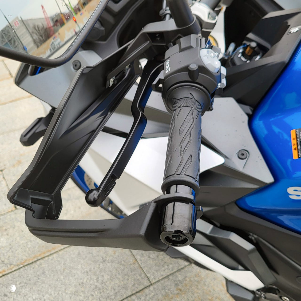 Детальный кадр пластиковой защиты рук и рукоятки GSXS1000GX, показывающий конструкцию и гибкость защиты вблизи тормозного рычага.