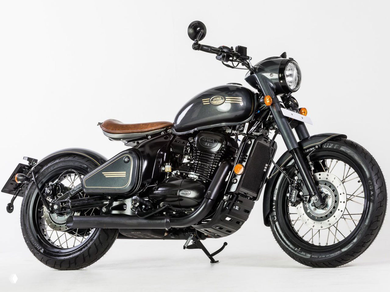 Чёрный боббер Jawa с коричневым одиночным сиденьем, чёрной выхлопной системой и спицованными колёсами на белом фоне.