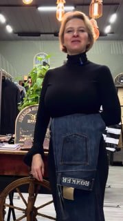 Человек в магазине демонстрирует джинсы с заметной накладкой и логотипом Rokker — кадр показывает посадку и внешний вид мотоджинсов в интерьере магазина.