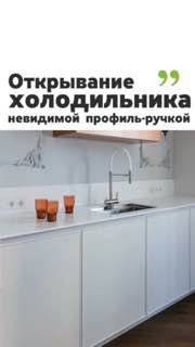Минималистичная белая кухня с интегрированными невидимыми профильными ручками на фасадах, видна мойка и чистая линия шкафов.