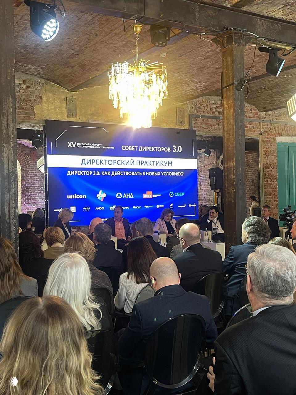 Панельная дискуссия на форуме «Совет директоров 3.0»: сцена с экранами и модераторами, аудитория слушает выступления, деловая встреча.