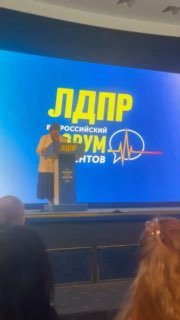Спикер на сцене форума ЛДПР на фоне большого экрана с логотипом «ЛДПР», зал слушателей и акцент на теме здравоохранения и выгорания