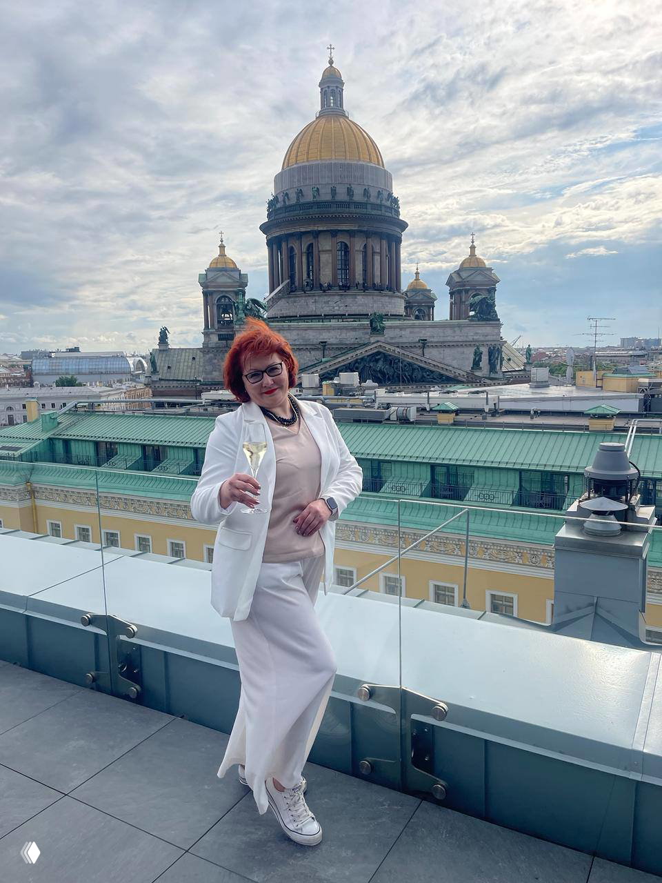 Ксения на крыше с бокалом шампанского на фоне золотого купола Исаакиевского собора — панорамный вид с террасы в Петербурге.