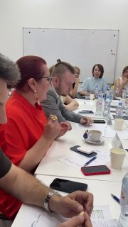 Участники круглого стола — маркетологи, пиарщики и предприниматели за столом, чашки, телефоны и заметки: кадр дискуссии во время мероприятия.