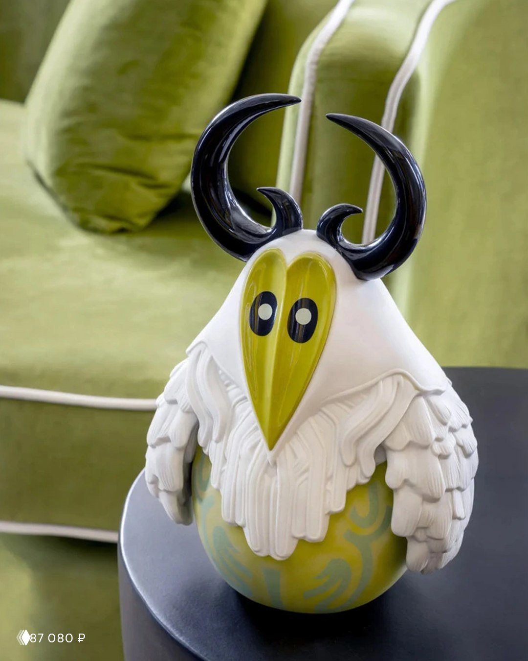 Крупный план фигурки Lladro «Ёкай. Тэнгу»: глянцевые рога, фисташковое основание и матовый белый фарфор, акцент на форму и фактуру изделия.