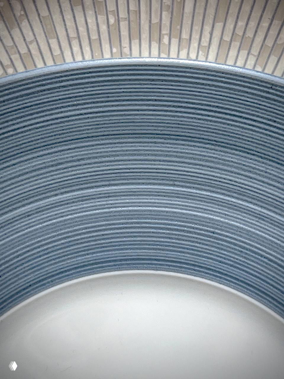 Внутренняя поверхность тарелки: голубовато-серая рифлёная фактура, концентрические линии и мягкая матовая отделка, подчёркивающая форму.