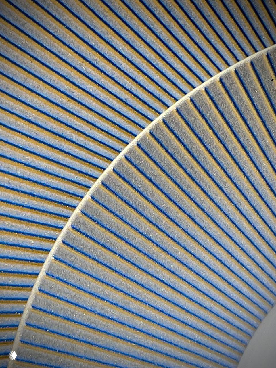 Макросъёмка текстуры фарфора: сине-бежевые рельефные линии, заметная зернистость глазури и глубокие параллельные канавки.