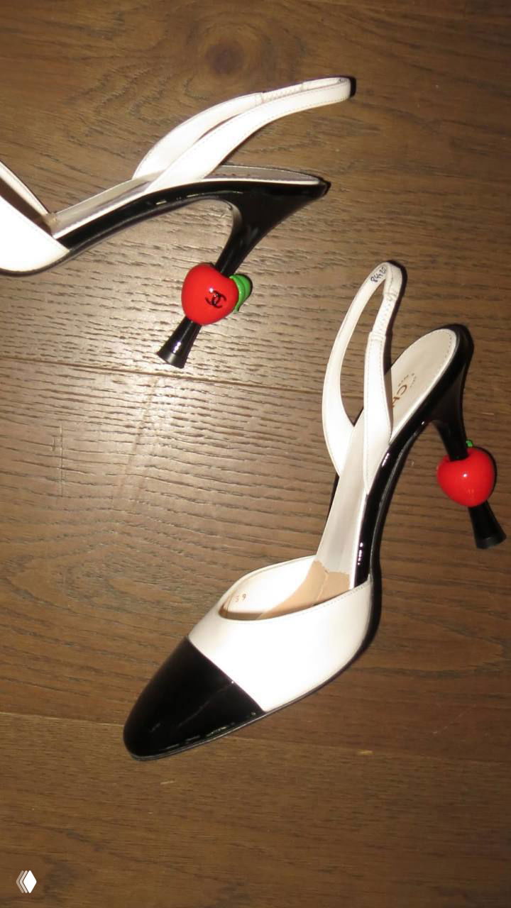 Белые туфли на тонком каблуке с декоративными ярко‑красными бусинами в виде вишен/яблок на каблуках — стилизованный кадр в контексте бьюти‑эстетики.