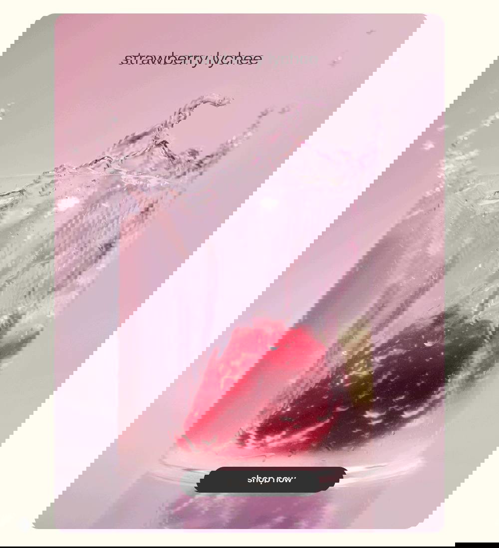 Розовый фон, стакан с брызгами воды и погружённой клубникой — динамичное промо-изображение вкуса «strawberry lychee».