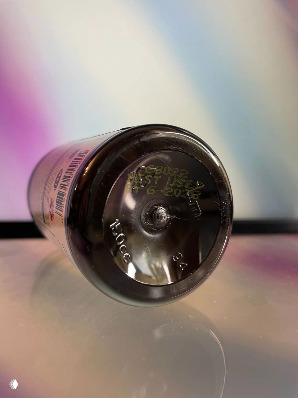 Крупный план нижней части флакона Carlson Super Omega‑3: видна тиснёная маркировка объёма и штамп с датой срока годности, снято на светлом фоне.