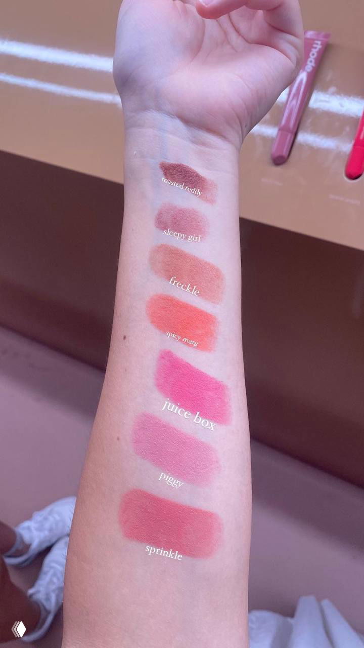 Свотчи румян на запястье: несколько оттенков, от нежно‑розового до ярко‑розового, показаны в естественном свете на коже для оценки пигментации.