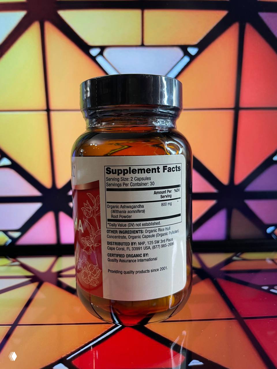Обратная сторона бутылки с табличкой Supplement Facts и составом (Organic Ashwagandha root powder), указана дозировка и информация о дистрибьюторе.