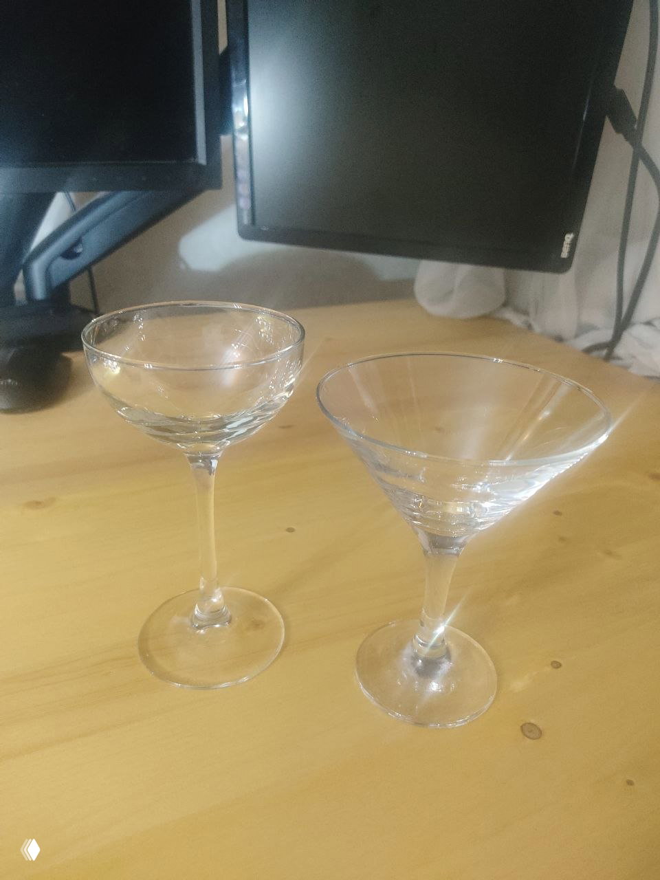 Две коктейльные рюмки на столе (купе и мартини) — демонстрация форм и объёмов, используемых для классических коктейлей.