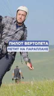 Мужчина в шлеме и параплане на старте в травянистом поле; над фото наложена надпись «Пилот вертолета летит на параплане», видна подготовка к взлёту.