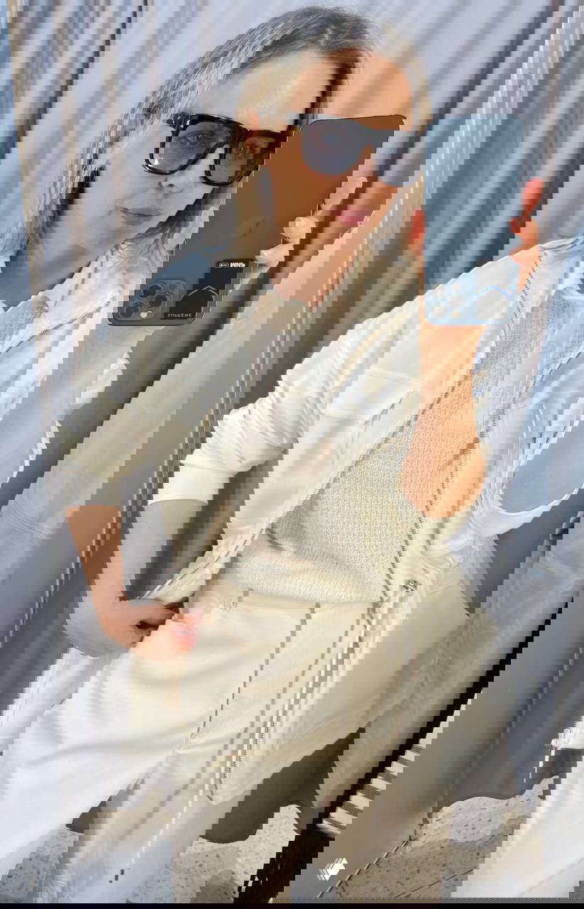 Крупный план: светлая куртка, текстурный белый джемпер-поло и светлые брюки из экокожи — вариант сочетания с юбкой или брюками.