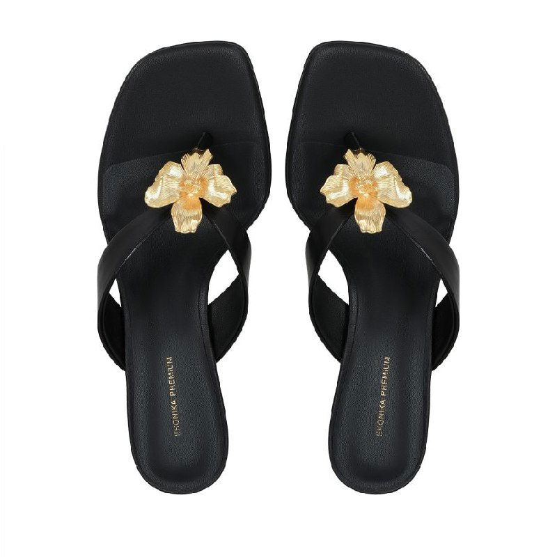 Чёрные шлёпанцы Ekоnika с декором на белом фоне, каталожная фотосъёмка сверху, акцент на фирменной стельке.