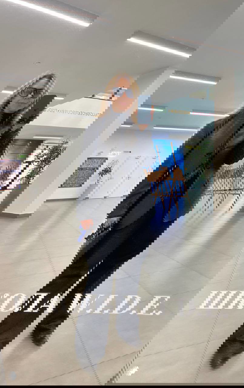 Селфи в солнцезащитных очках и чёрном пиджаке из кожи, широкие брюки и сумка — строгий монохромный образ в зеркальном помещении.