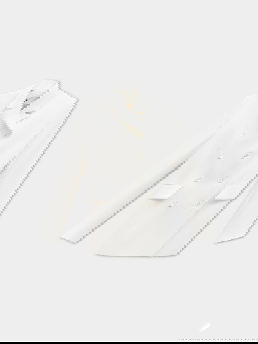 Товарное фото белого двубортного жакета на светлом фоне, демонстрирующее форму, пуговицы и силуэт для капсульного гардероба.