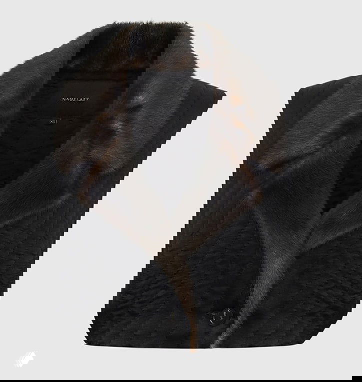 Черная стеганая безрукавка с отложным меховым воротником на светлом фоне — акцентный верх для слоёв в капсуле.