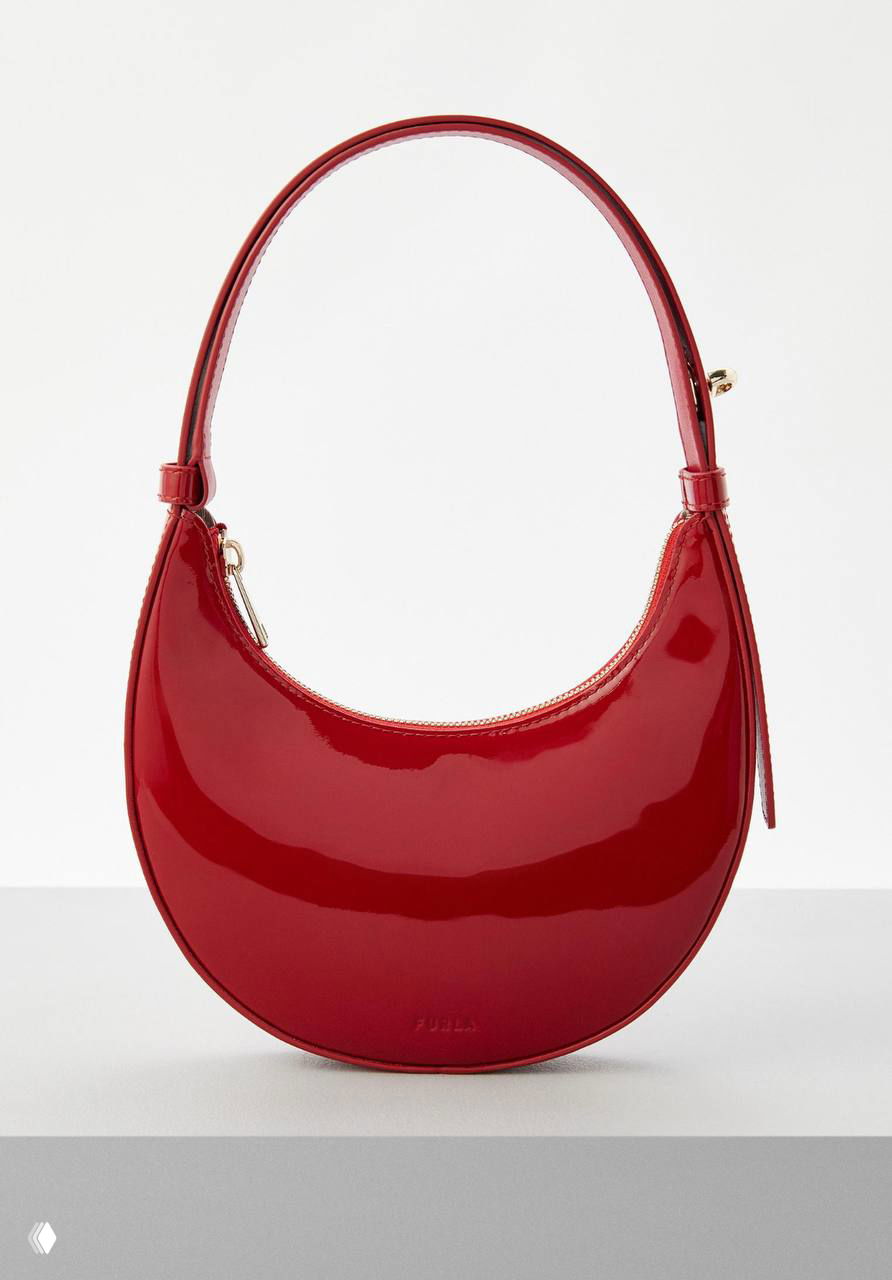 Лакированная полукруглая красная сумка Furla на светлом подиуме, подчёркнут блеск материала и аккуратная ручка