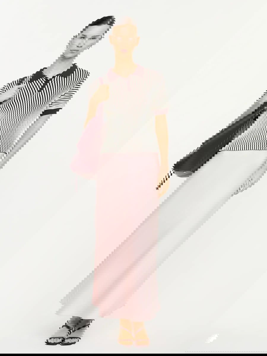 Розовая макси-юбка в паре с полосатым топом; минималистичный, мягкий образ в пастельных тонах для тёплой погоды.