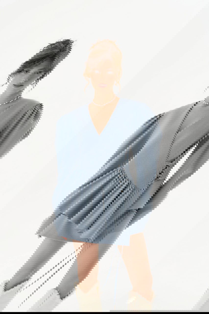 Голубой укороченный пиджак-платье с глубоким V‑декольте, драпировкой и пышными рукавами — лёгкий романтичный образ для офисного и вечернего выхода.