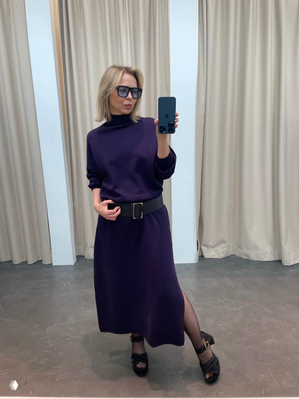 Зеркальное селфи в примерочной: тёмно‑фиолетовое трикотажное платье с широким поясом и чёрными туфлями, стильный монохром.