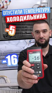 Мастер держит цифровой термометр с показанием −16°C на фоне морозильной камеры холодильника Samsung No Frost во время ремонта.