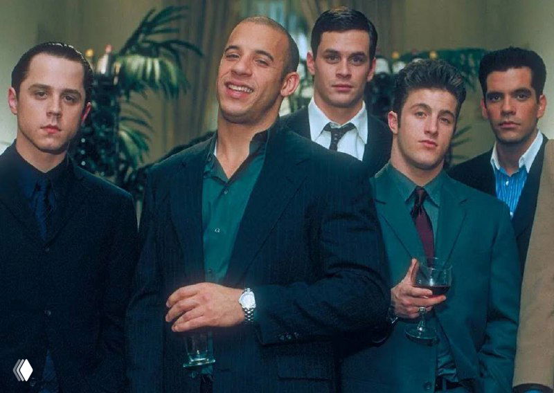 Группа мужчин в костюмах на официальном приёме; изображение частично искажено артефактами, но видно деловую обстановку и гостей.