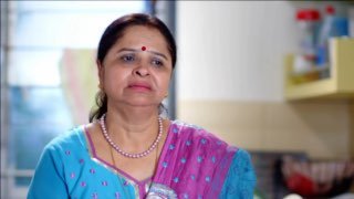 Кадр из ролика: индийская женщина среднего возраста с бинди и лёгкой грустью, домашний интерьер на заднем плане, эмоция ностальгии.