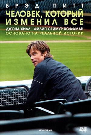 Постер фильма «Человек, который изменил всё»: мужчина в тёплой одежде сидит у гоночного трека, приглушённые синие тона, рекламный постер