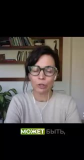 Ольга Белогривцева в кадре: крупный план, в очках, говорит на фоне полки с книгами и комнатного растения; спокойная обучающая атмосфера.