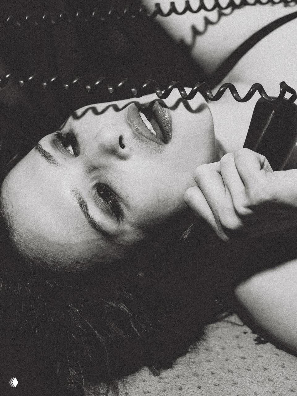 Чёрно‑белая крупная композиция: Лукерья Ильяшенко с телефонной трубкой у уха, подчеркнутый винтажный нуарный стиль и макияж.