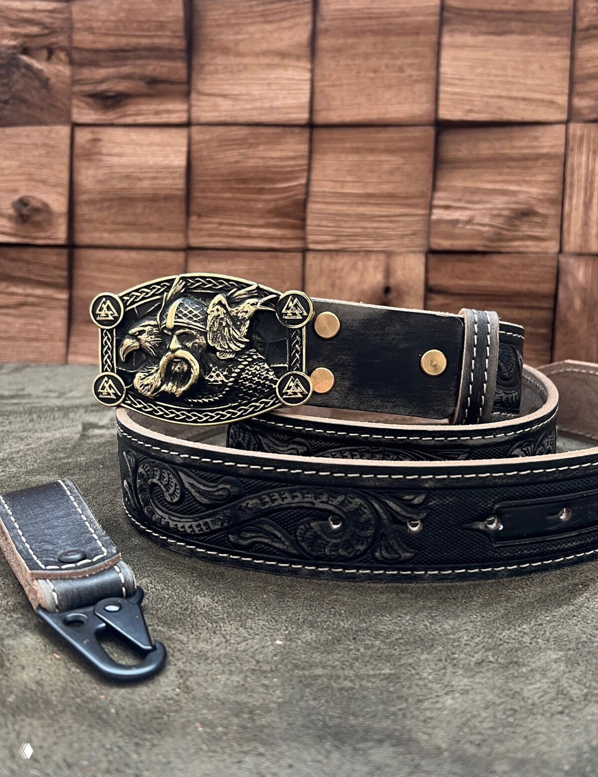 Чёрный кожаный ремень с орнаментным тиснением и декоративной бронзовой пряжкой в виде ворона и рунических элементов.