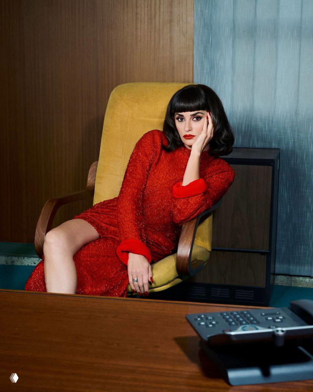 Женщина в ярко-красном платье сидит в кресле ретро-офиса; крупный план, выразительный взгляд и стилизованный интерьер.