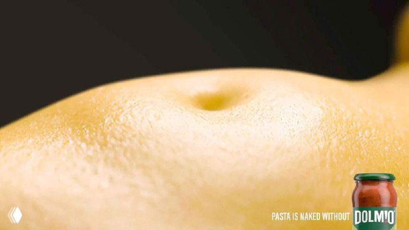 Крупный план баннера Dolmio: текстура пасты напоминает кожу, в кадре заметна банка соуса, подчёркивается концепция «паста без соуса — голая».