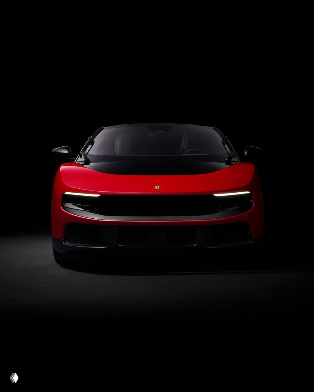 Фронтальный вид красного электрокара Ferrari Luce на чёрном фоне; узкие светодиодные фары и минималистичная решётка подчёркивают дизайн.